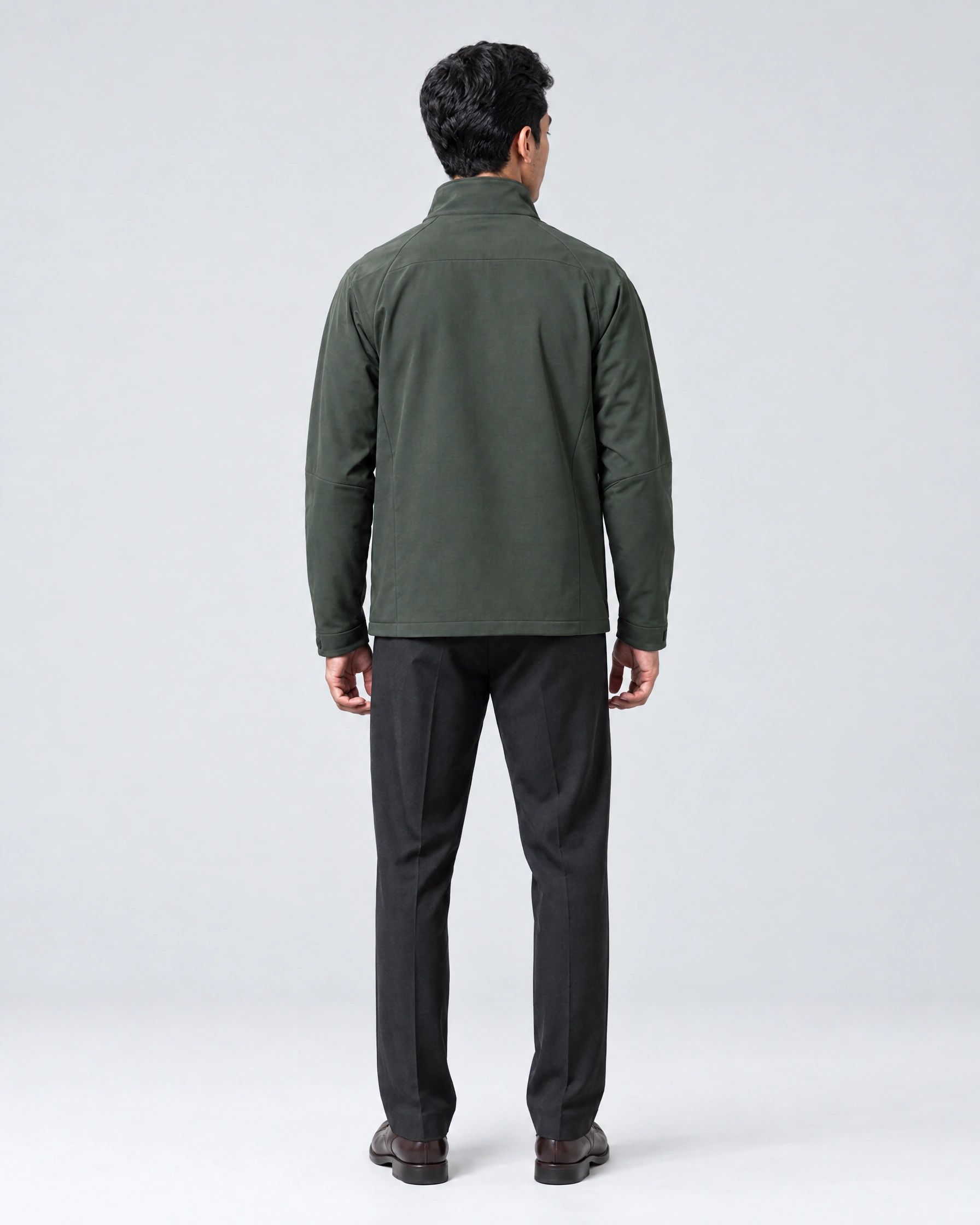 Twin wearing an olive jacket and black trousers, back view